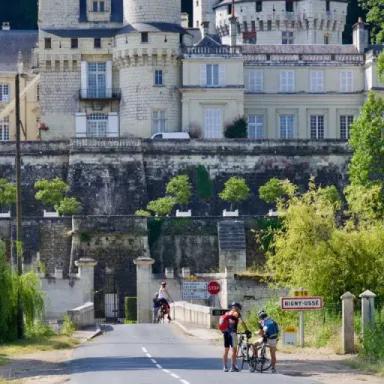 Cyclists riding along a lakeside path surrounded by alpine mountains, during cycling in North Italy