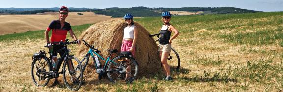 Cycling Central Italy tour with cyclists riding across open countryside and rolling hills